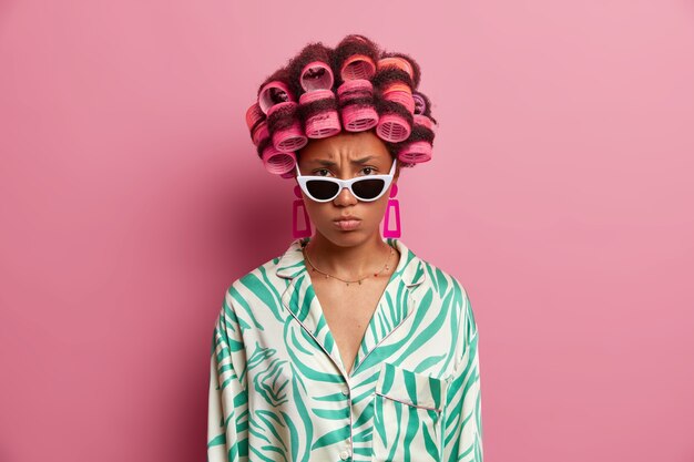 Beautiful lady wearing hair curlers isolated