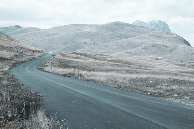 Free photo beautiful landscape of a road rolling hills on a cloudy day