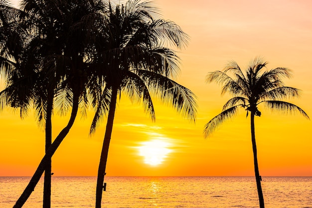 Free photo beautiful landscape of sea ocean with silhouette coconut palm tree at sunset or sunrise