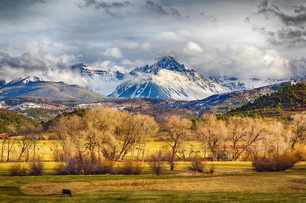 Beautiful landscape of snow covered mountain, rolling hills and a flat pasture land