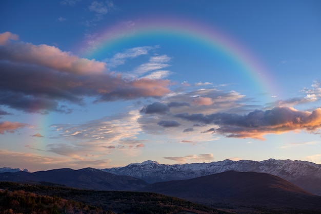 Free photo beautiful landscape with rainbow and clouds