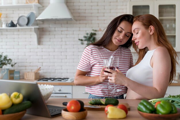 Beautiful lesbian couple cheering with some glasses of wine