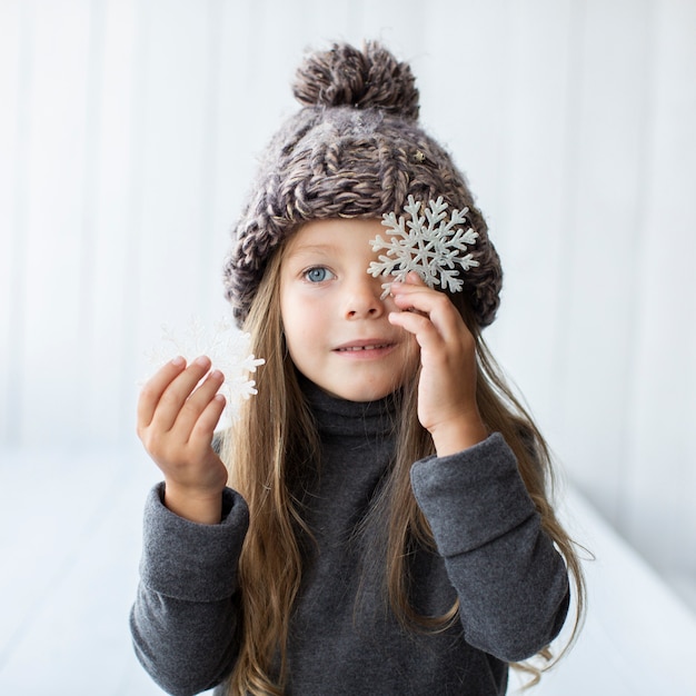 Free photo beautiful little girl holding snowflakes