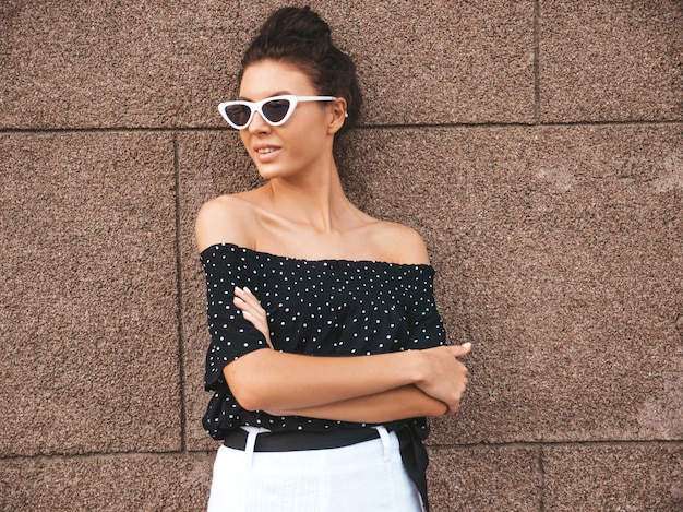 Free Photo beautiful model dressed in elegant summer clothes.sexy carefree girl posing in the street near wall.trendy modern businesswoman in sunglasses having fun