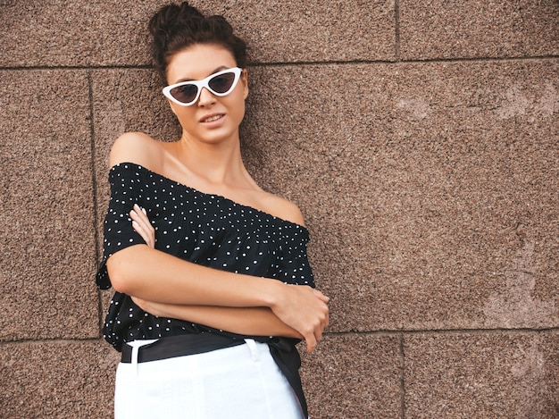 Free Photo beautiful model dressed in elegant summer clothes.sexy carefree girl posing in the street near wall.trendy modern businesswoman in sunglasses having fun