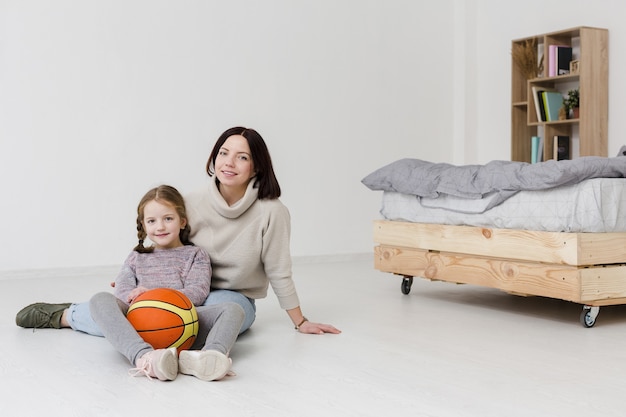 Free photo beautiful mom and daughter posing indoors