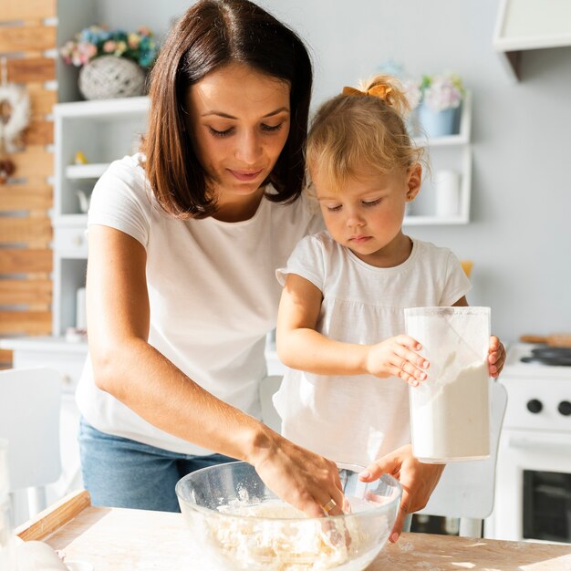 Beautiful mother and lovely daughter cooking together