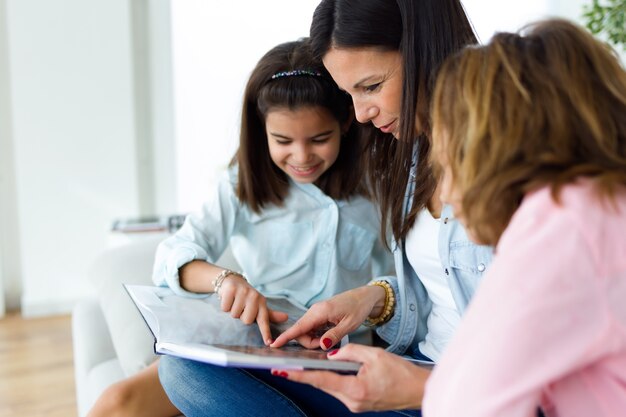 Beautiful mother with her daughters reading a book at home.