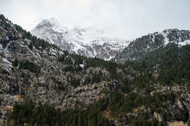 Beautiful mountain range covered with snow enveloped in fog