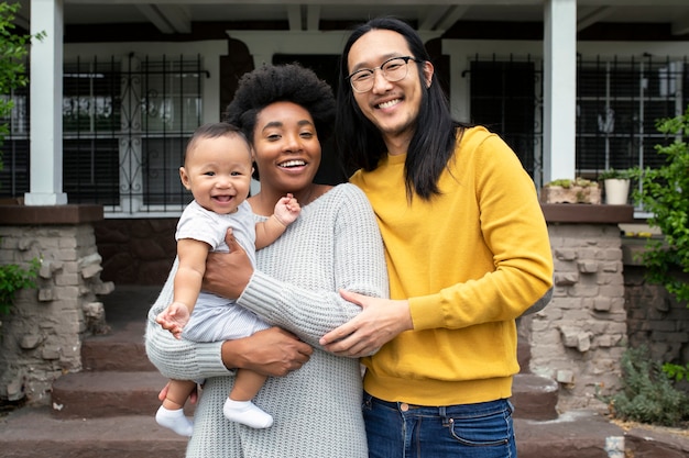 Free photo beautiful multiethnic family standing at the porch during covid19 lockdown