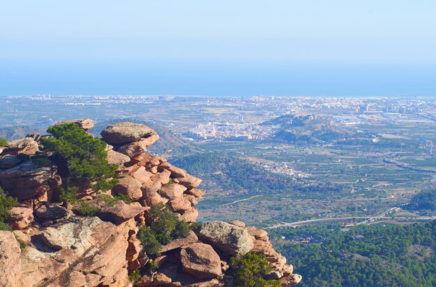 Beautiful natural landscape with rocky cliffs surrounded by greenery under a bright sky