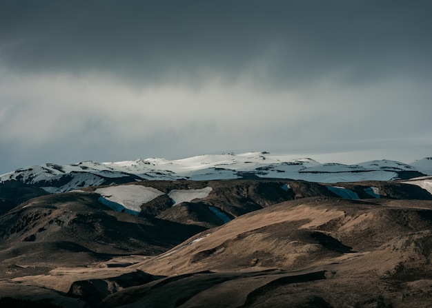 Beautiful natural scenery with snowy hills and dark grey sky