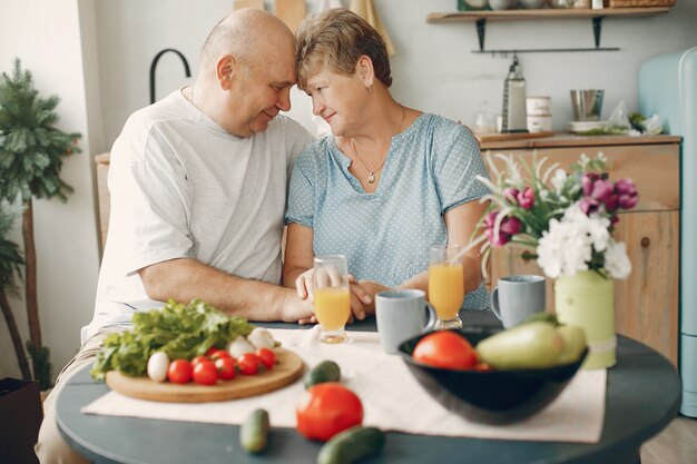 Beautiful old couple prepare food in a kitchen