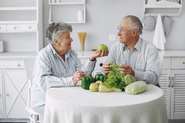 Beautiful old couple prepare food in a kitchen