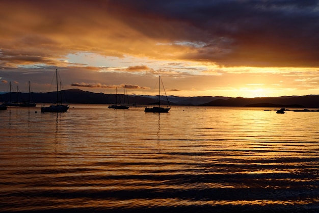 Free Photo beautiful orange toned sunset with boat silhouettes in santo antonio de lisboa,florianopolis,brazil