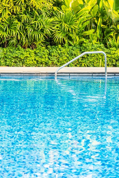 Beautiful outdoor swimming pool with bed deck chair and umbrella in resort for travel and vacation