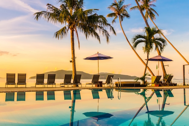 Beautiful outdoor view with umbrella and chair around swimming pool in luxury hotel