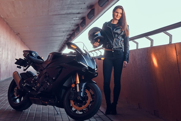 Free Photo beautiful pensive woman is standing in tunnel with her bike and helmet.