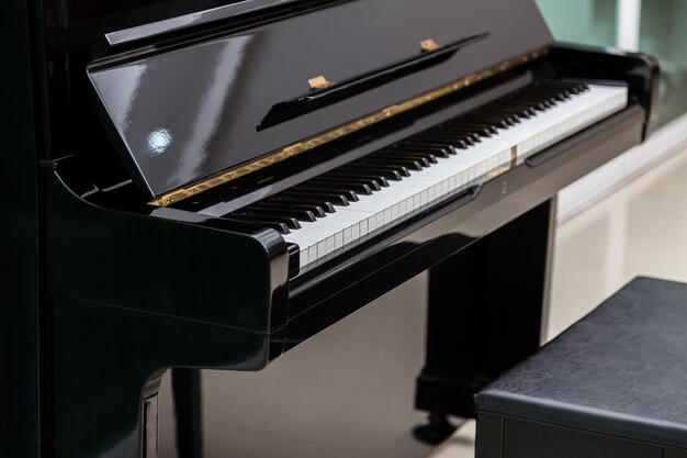 Beautiful piano next to a stool