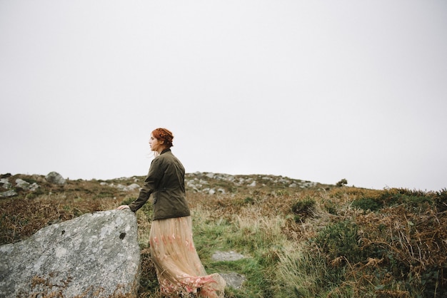 Beautiful picture of a ginger female with a pure white skin in an attractive light pink gown