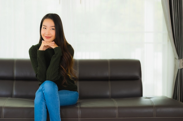 Beautiful portrait young asian woman sit relax on sofa