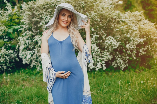 Beautiful pregnancy woman in a summer park