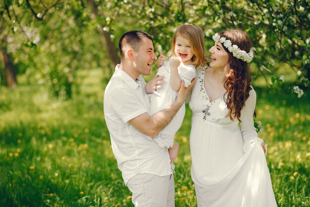 beautiful pregnant girl in a long white dress with her boyfriend and their little daughter