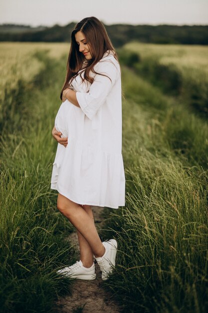 Beautiful pregnant woman in a field