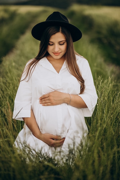 Beautiful pregnant woman in a field