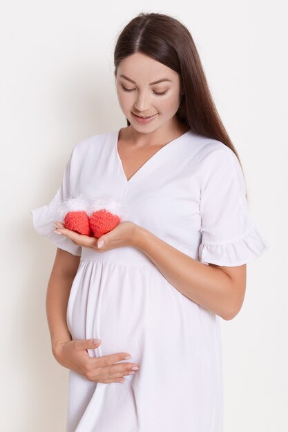 Beautiful pregnant woman wearing white dress