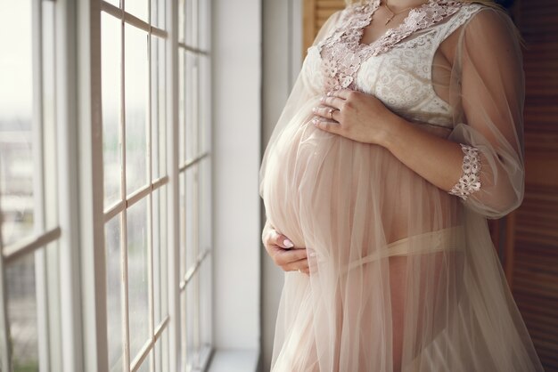 Beautiful pregnant woman with big belly in a studio