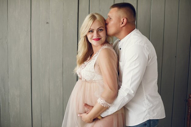 Beautiful pregnant woman with her husband in a studio