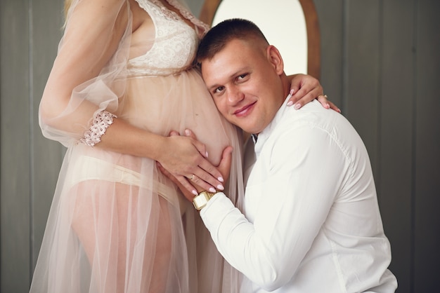 Beautiful pregnant woman with her husband in a studio