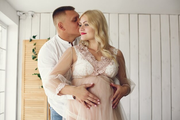 Beautiful pregnant woman with her husband in a studio