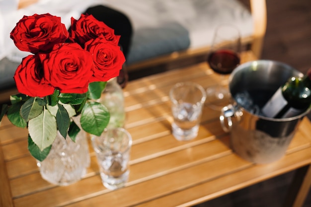 Free photo beautiful red roses vase on wooden table