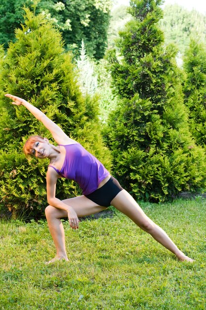 Beautiful red woman doing fitness or yoga exercises