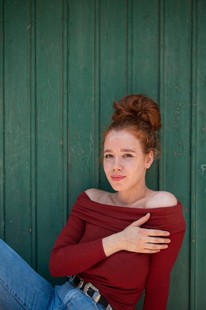 Beautiful redhead woman posing with green background