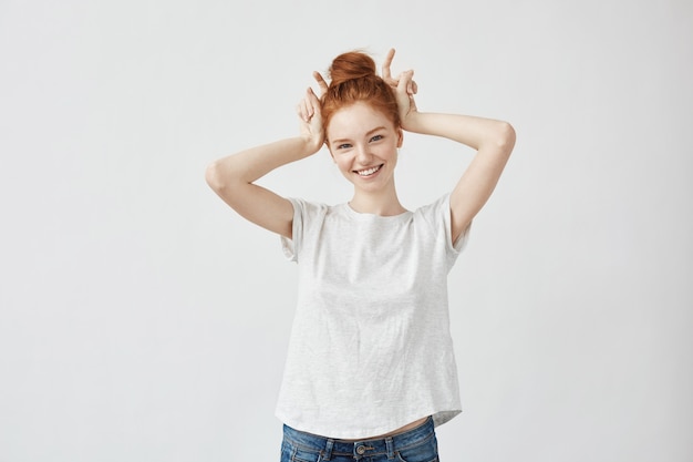 Beautiful redhead woman smiling showing hare hands.