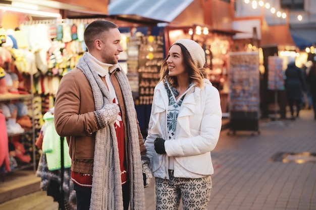 Beautiful romantic couple enjoy their Christmas day on traditional festive market.