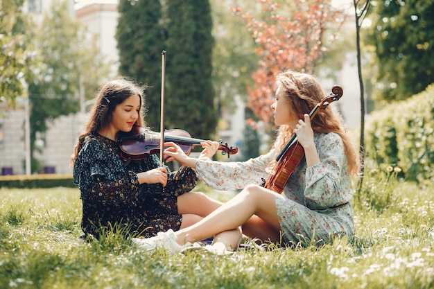 Beautiful and romantic girls in a park with a violin