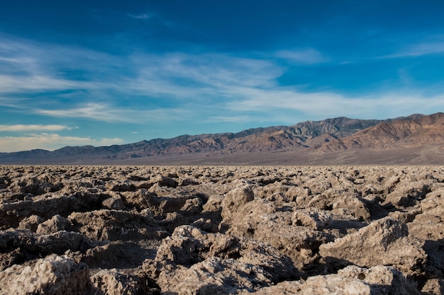 Free photo beautiful scene of a rocky ground in a desert and the bright blue sky in the background