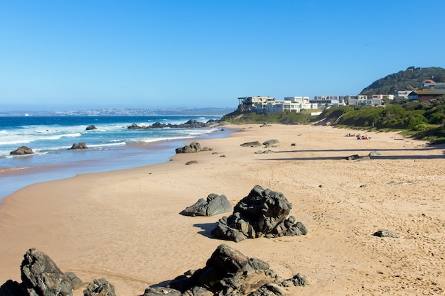 Free photo beautiful scenery of a beach surrounded by hills under the clear sky