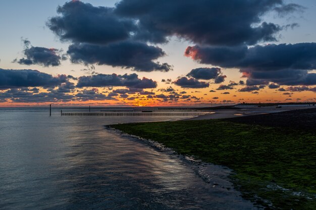 Beautiful scenery of a breathtaking sunset over the calm ocean in Westkapelle, Zeeland