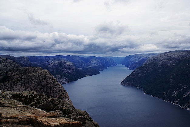 Free Photo beautiful scenery of famous preikestolen cliffs near a lake under a cloudy sky in stavanger, norway