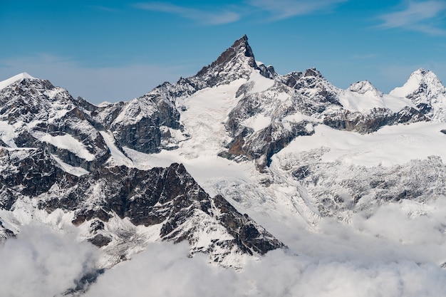 Beautiful scenery of high rocky mountains covered with snow under a clear blue sky in Switzerland