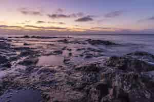 Free photo beautiful scenery of huge rock formations near the sea under the breathtaking sunset sky