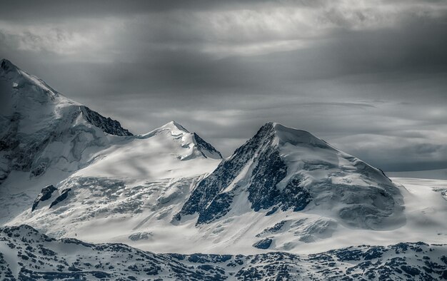 Beautiful scenery of a mountain range covered with snow under the cloudy sky