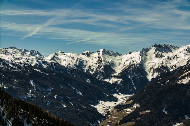 Free photo beautiful scenery of a range of rocky mountains covered with snow under a cloudy sky