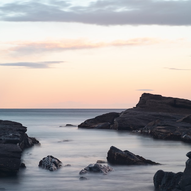 Free photo beautiful scenery of rock formations in the sea under the breathtaking colorful sky