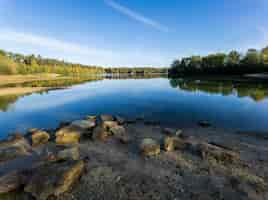 Free photo beautiful scenery of rocks near a tranquil lake under a blue sky